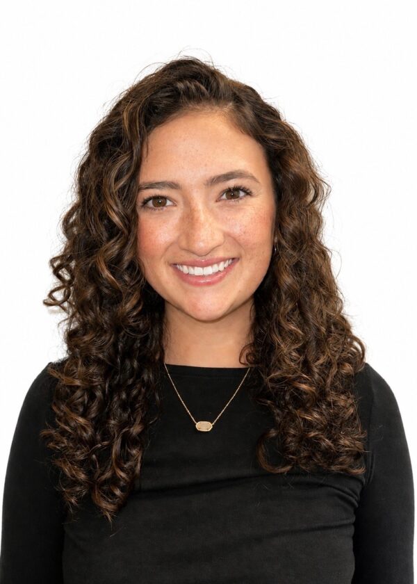 Photo of smiling woman with long curly hair in a black long sleeve top