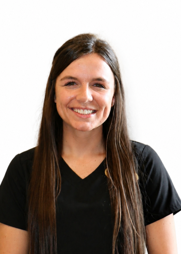 Photo of woman with long brown hair in a black scrub top